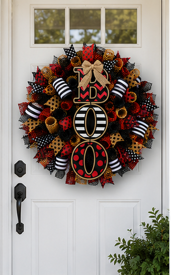 Large handcrafted Halloween BOO wreath decorating a front door with premium deco mesh, wired ribbon, and bold Halloween colors.