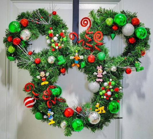 Handmade Christmas mouse-inspired wreath featuring lush evergreen garland, red, green, and silver ornaments with festive holiday accents displayed on a front door.