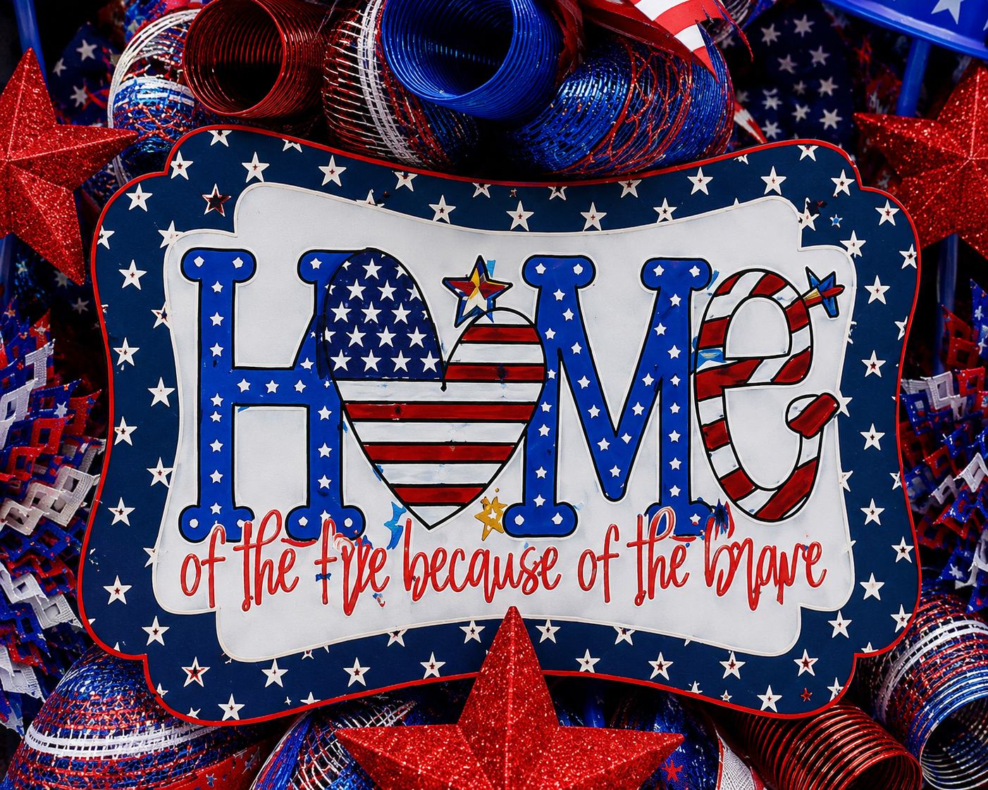 Close-up of the Home of the Free Because of the Brave patriotic centerpiece surrounded by designer ribbon.