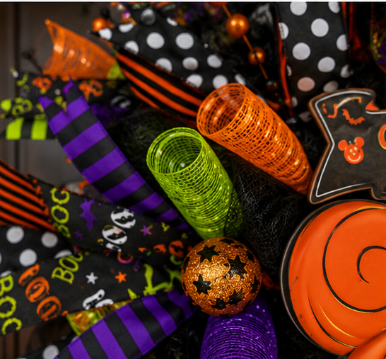 Close-up of the pumpkin mouse-inspired centerpiece surrounded by colorful Halloween ribbons, mesh, and festive decorations.